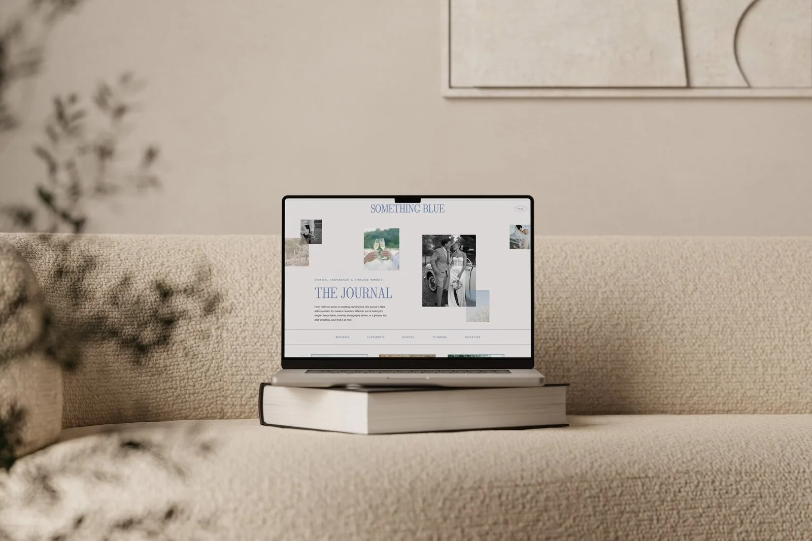 Laptop on a beige sofa displaying a website template with THE JOURNAL visible.