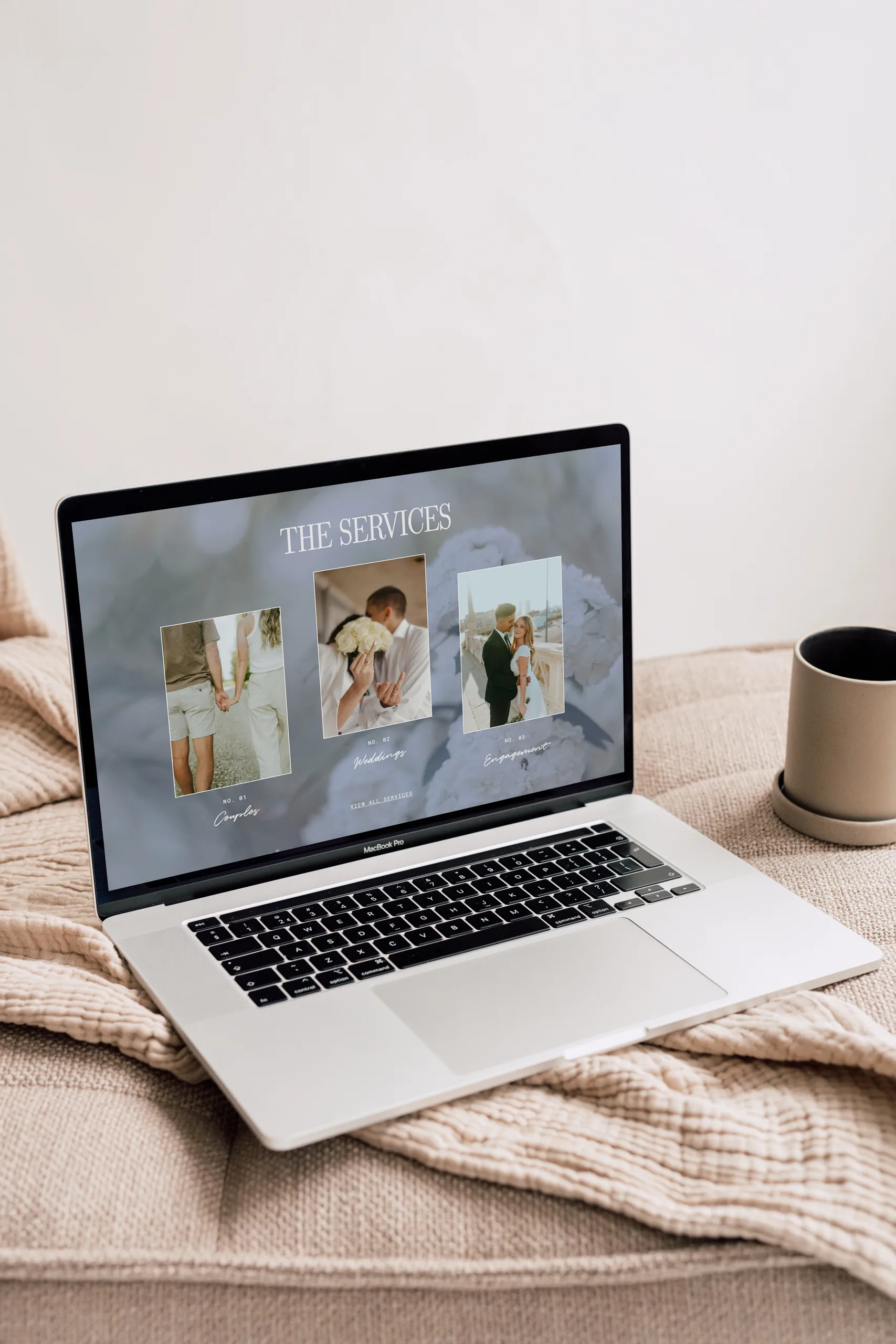 Laptop on a bed displays a services page with three image tiles.